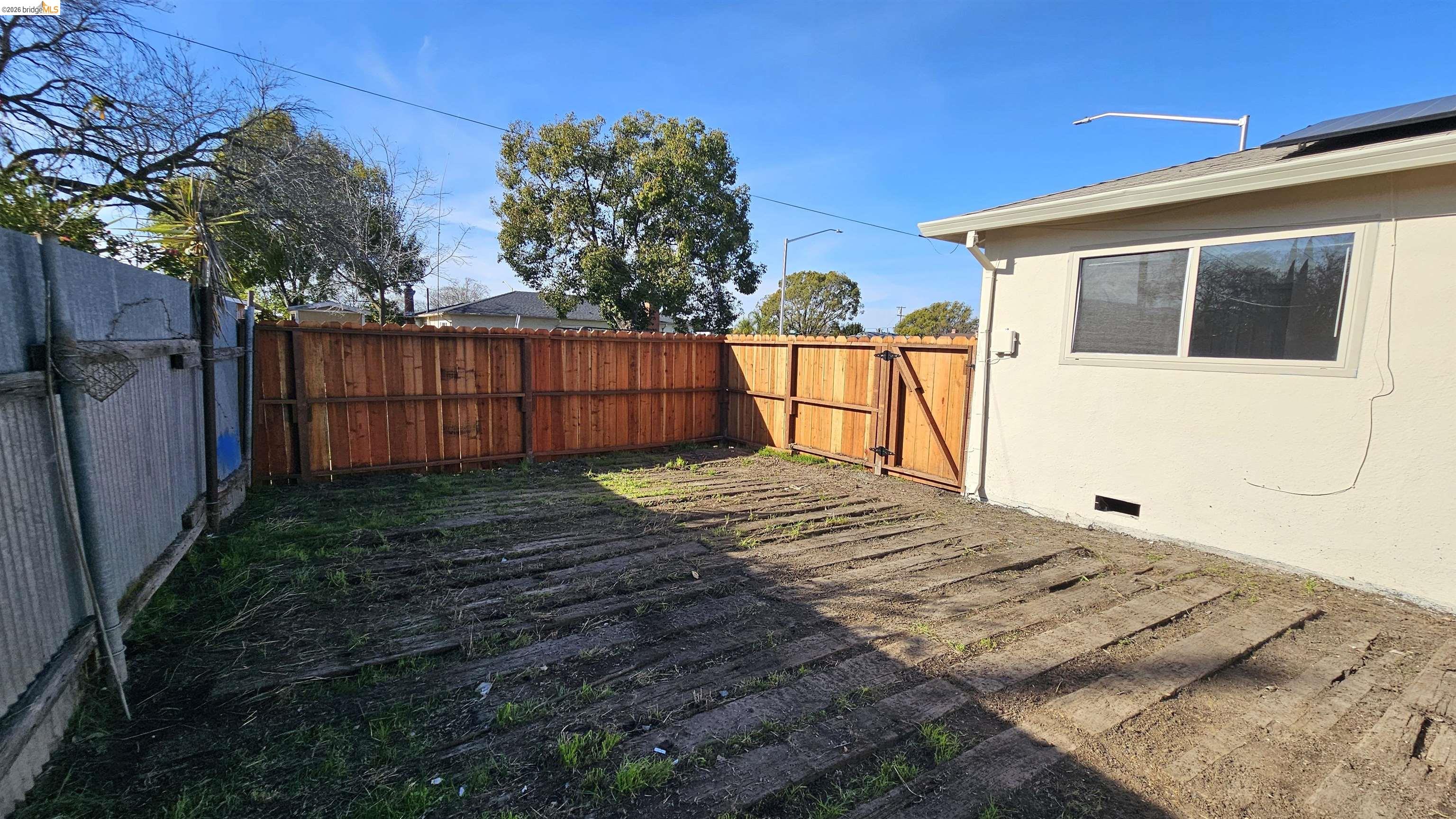 95 West Leland Road Pittsburg, CA 94565 - Photo 22 of 25 a bed sitting in front of a house with wooden fence