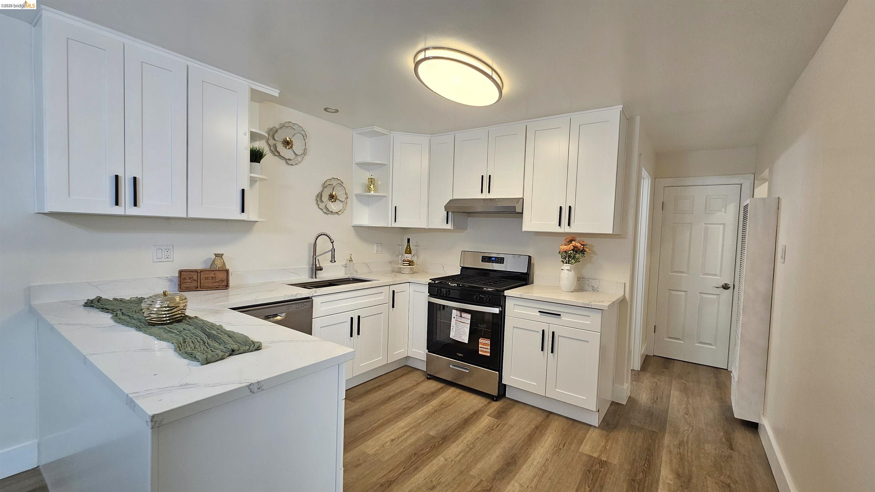95 West Leland Road Pittsburg, CA 94565 - Photo 7 of 25 a kitchen with cabinets stainless steel appliances and wooden floor