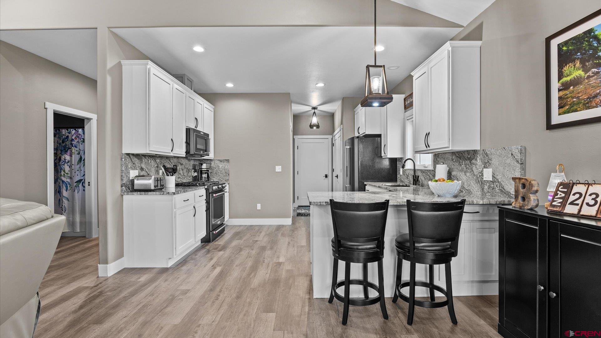67190 Sunnyside Road Montrose, CO 81401 - Photo 19 of 41 a kitchen with stainless steel appliances kitchen island granite countertop a dining table chairs and sink