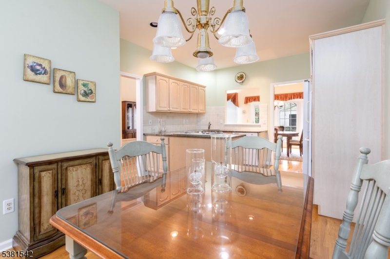 12 Hurlingham Club Road Far Hills, NJ 07931 - Photo 19 of 31 a kitchen with stainless steel appliances granite countertop a stove a sink a dining table and chairs with wooden floor