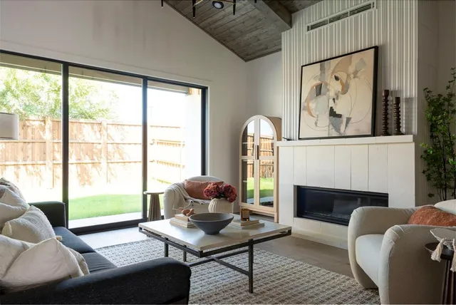 a living room with furniture a fireplace and a floor to ceiling window