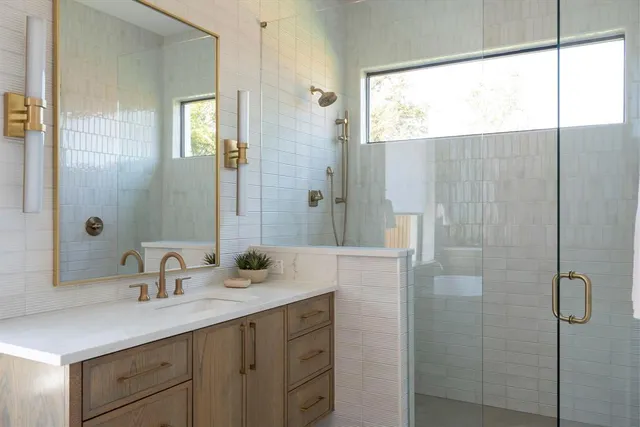 a bathroom with a shower sink and mirror