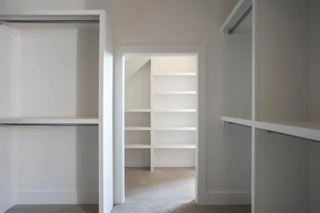 a view of walk in closet with empty racks