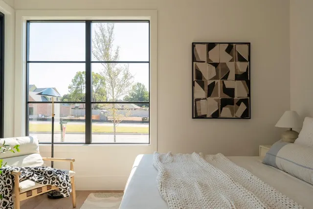 a bedroom with a bed and a large window with the outer view