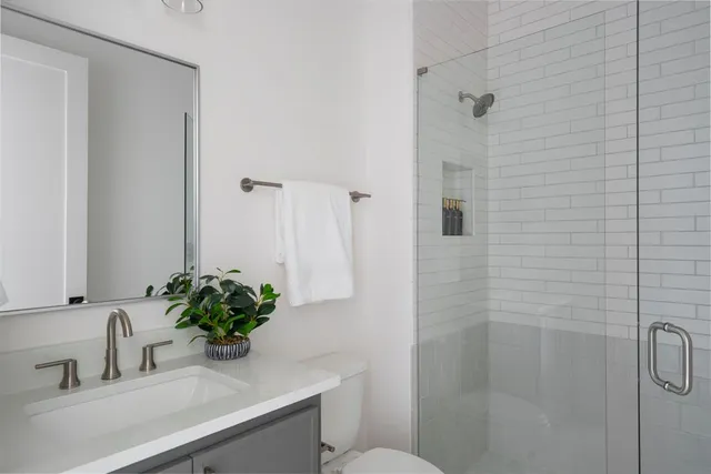 a bathroom with a sink a toilet and shower