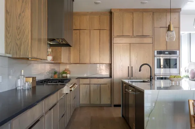 a kitchen with stainless steel appliances granite countertop a sink a stove and refrigerator