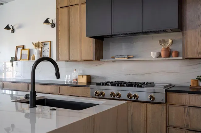 a kitchen with a sink a stove and cabinets