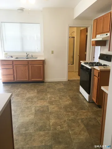 a view of kitchen with granite countertop a sink a counter top space and cabinets