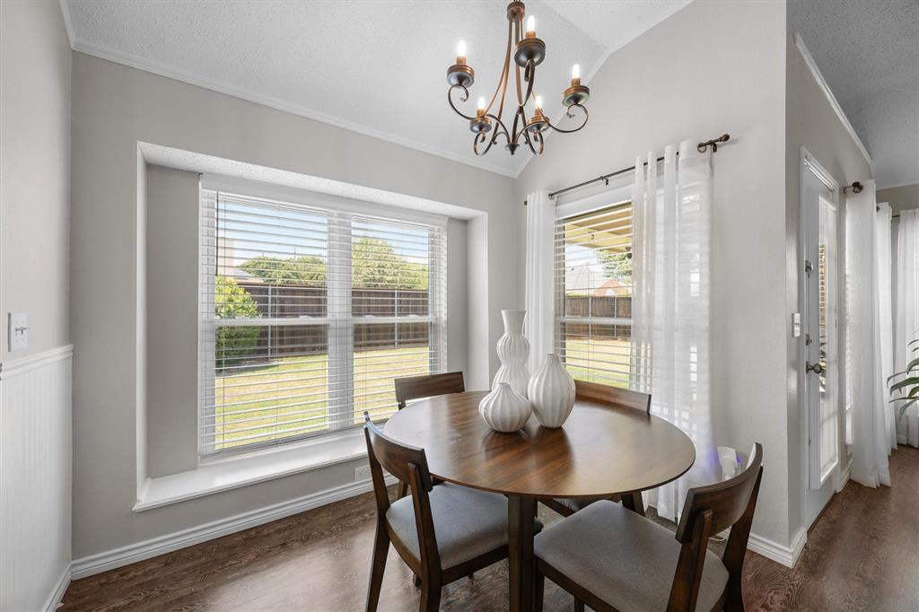 10714 Huntington Road Frisco, TX 75035 - Photo 10 of 24 High ceiling with an iron chandelier, wood-finish flooring, and a large window overlooking the backyard