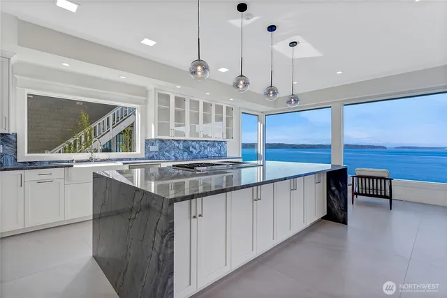 a large kitchen with kitchen island a large counter space a sink a center island and stainless steel appliances