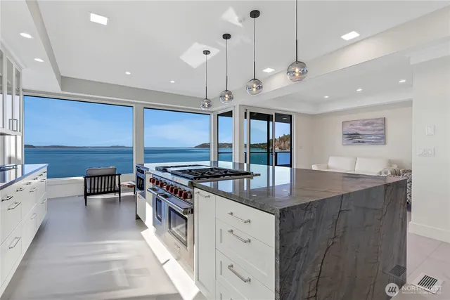 a kitchen with stainless steel appliances granite countertop a sink a stove and a wooden floors