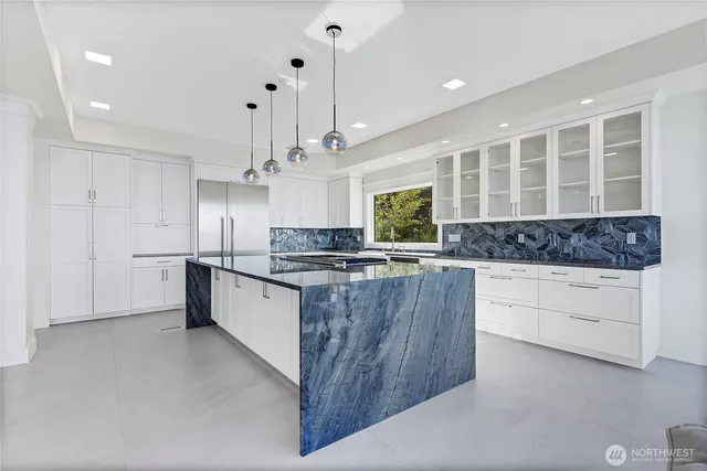 a large kitchen with kitchen island a large counter space stainless steel appliances and cabinets