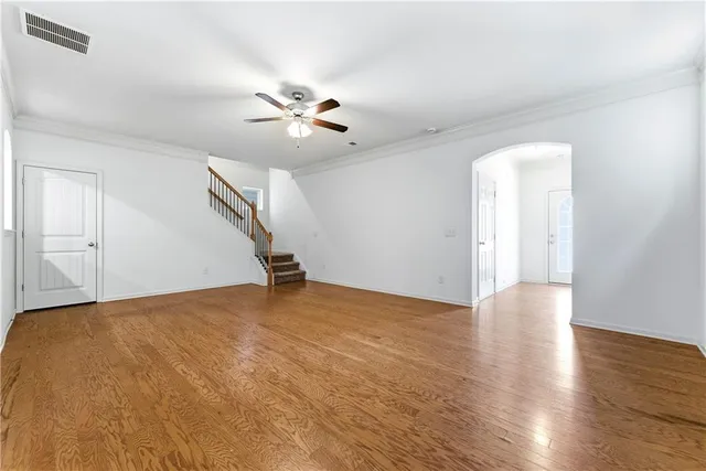 a view of an empty room with window and wooden floor