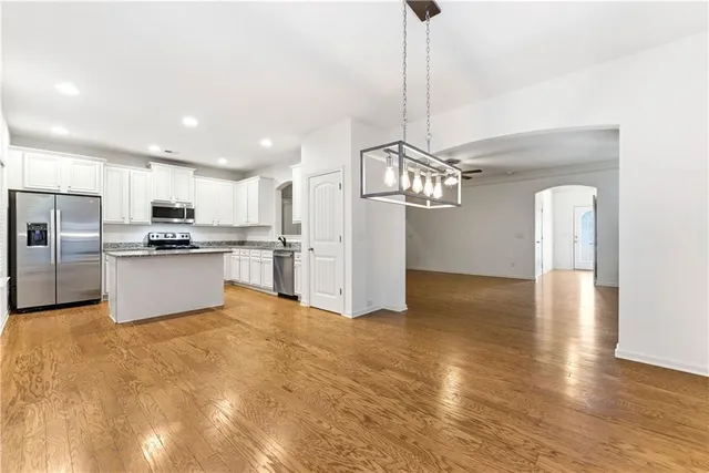 a kitchen with stainless steel appliances granite countertop a refrigerator a sink a stove a microwave and island