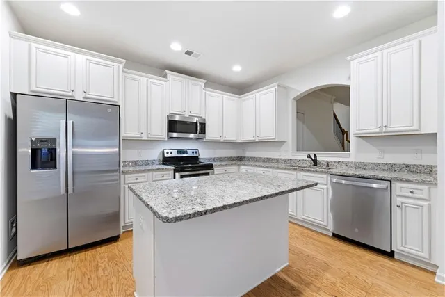a kitchen with granite countertop a sink a stove and microwave