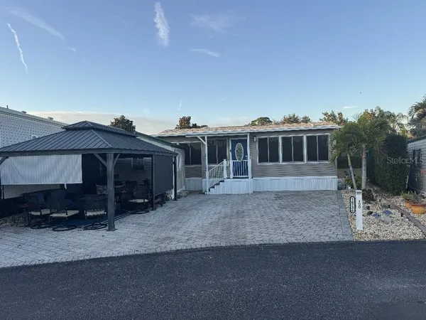 a view of a house with backyard and sitting area