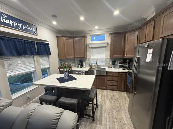 a kitchen with a refrigerator a stove a sink and cabinets
