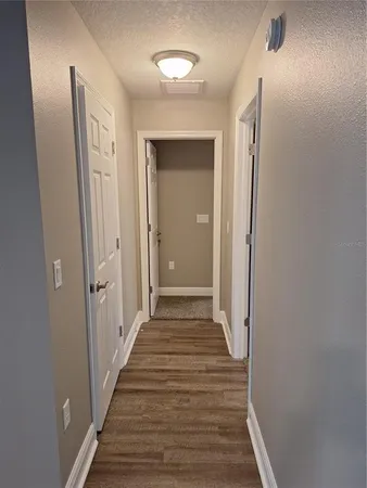 a view of a hallway with wooden floor and staircase