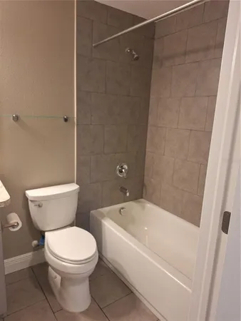 a white toilet sitting next to a bath tub