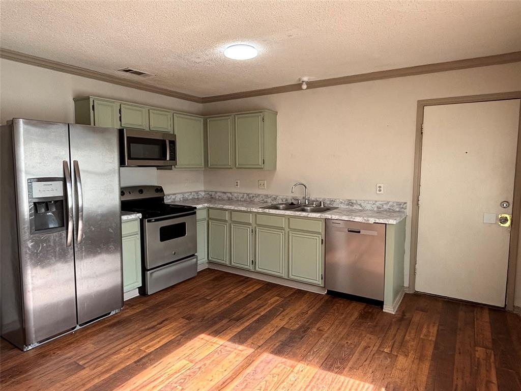 2313 Foot Hill Road McKinney, TX 75072 - Photo 4 of 13 a kitchen with a refrigerator and a sink