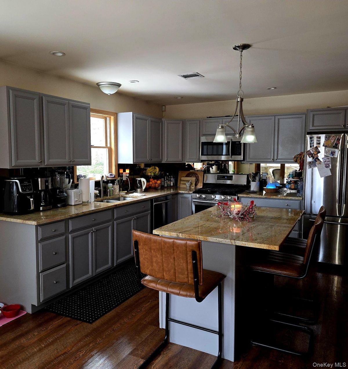 85 Swinging Bridge Estate Road Monticello, NY 12701 - Photo 3 of 12 a kitchen with stainless steel appliances kitchen island granite countertop a sink a stove a refrigerator cabinets and chairs