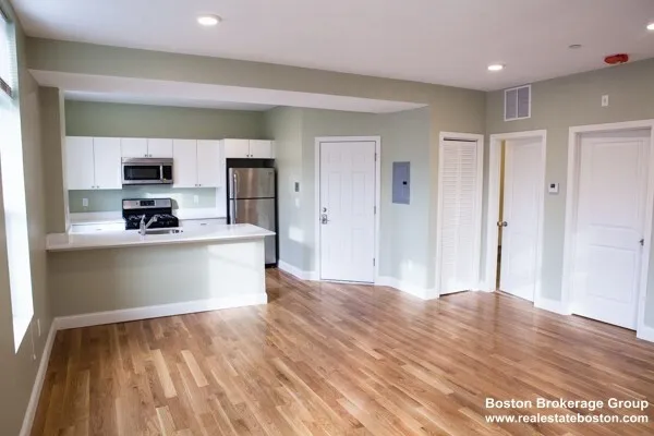 a room with kitchen island a sink wooden floor and view living room