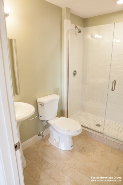 10 Roxbury Street, Unit 9 Boston, MA 02119 - Photo 3 of 8 a bathroom with a toilet and a shower