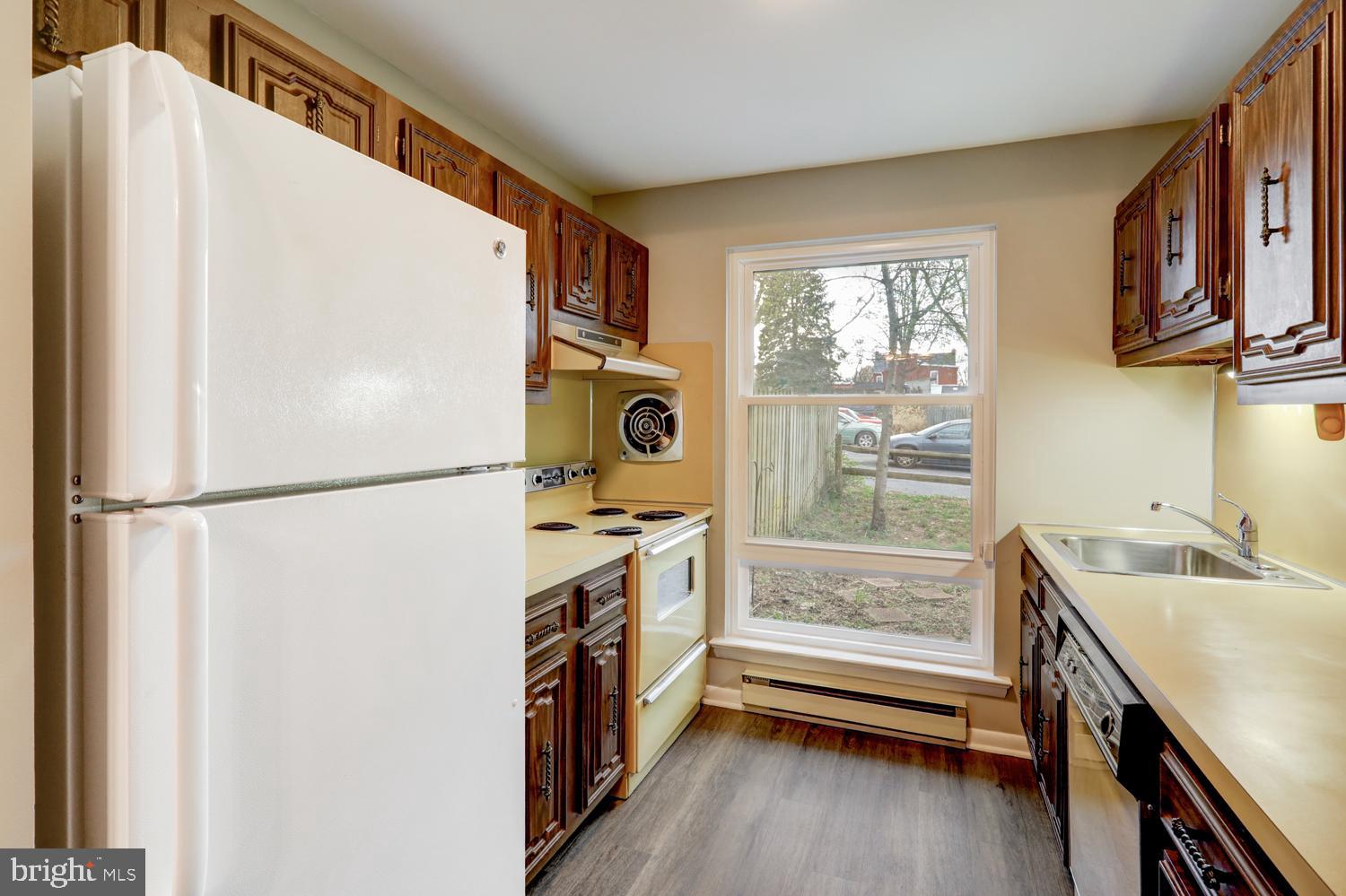 813 Fremont Street Lancaster, PA 17603 - Photo 8 of 33 a kitchen with a refrigerator a sink and wooden cabinets