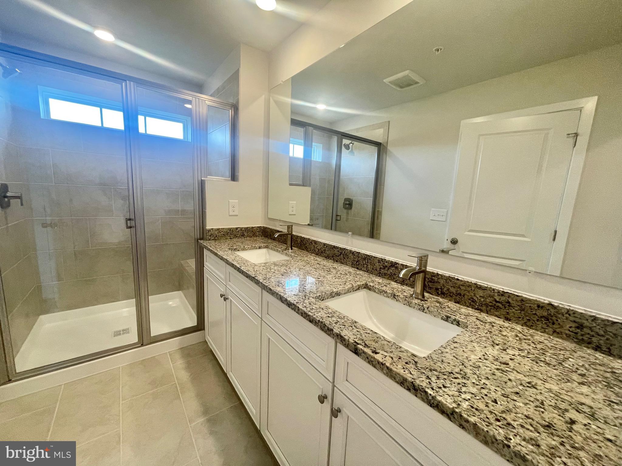 2264 Marcy Drive Frederick, MD 21702 - Photo 26 of 39 a bathroom with a granite countertop sink a mirror and a shower