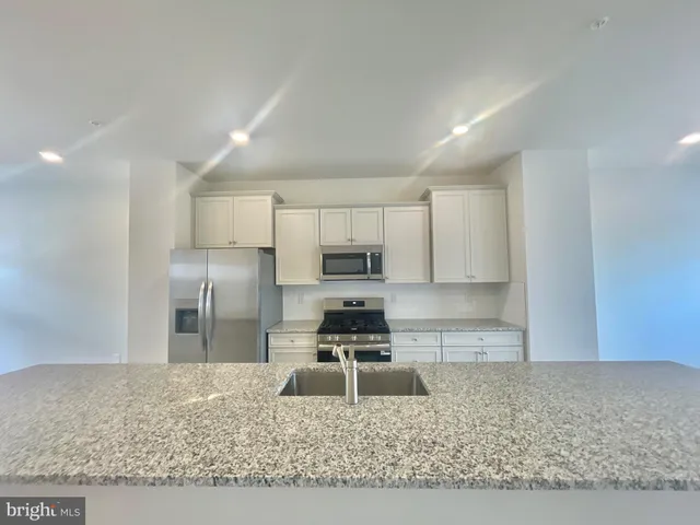 a kitchen with a refrigerator sink and cabinets
