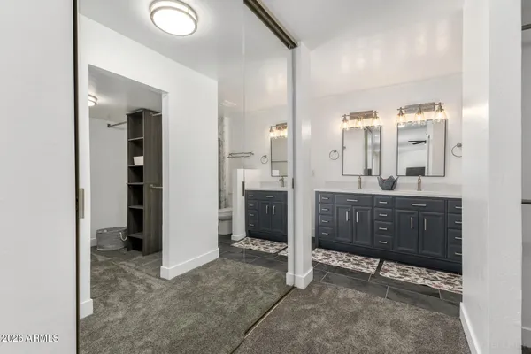 a bathroom with double sink and two mirror