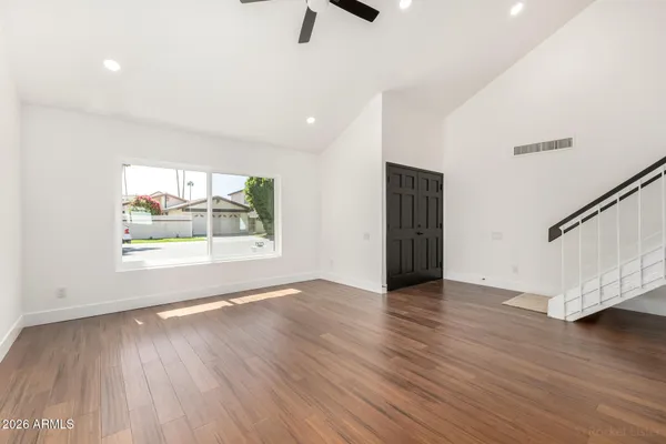 a view of an empty room with wooden floor and a window