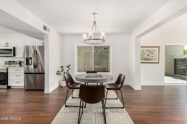 a kitchen with granite countertop a table and chairs in it