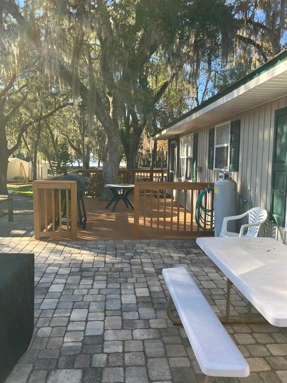 25079 Northeast 140th Loop Salt Springs, FL 32134 - Photo 20 of 23 a view of a backyard with table and chairs with wooden fence and plants