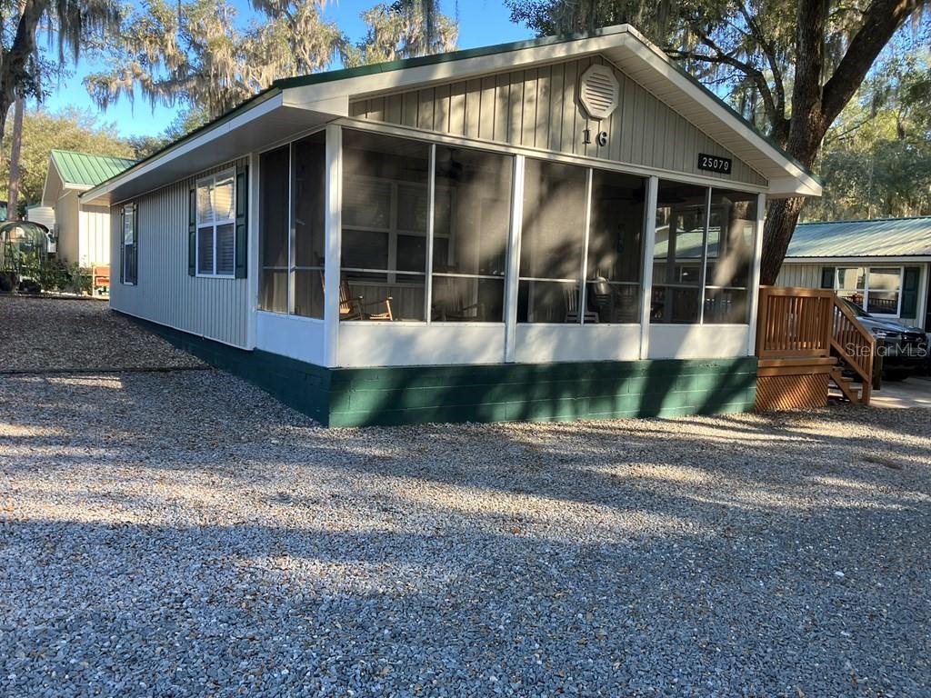 25079 Northeast 140th Loop Salt Springs, FL 32134 - Photo 2 of 23 a front view of a house with a yard and glass windows