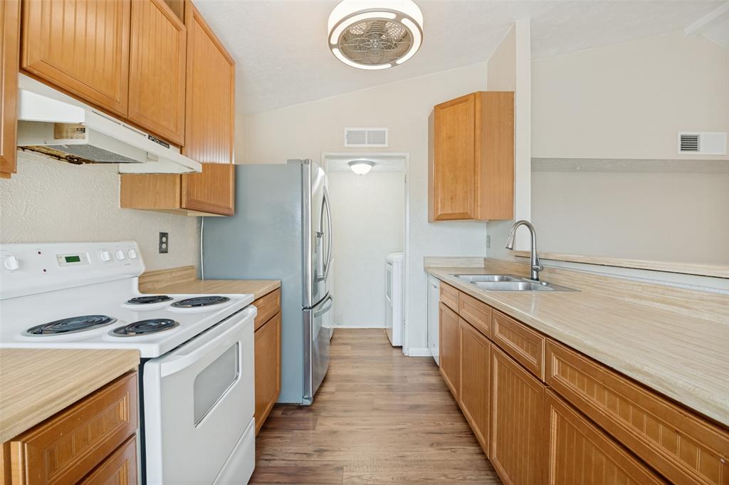 7305 Pineberry Road Dallas, TX 75249 - Photo 11 of 25 a kitchen with stainless steel appliances a stove a sink and a refrigerator