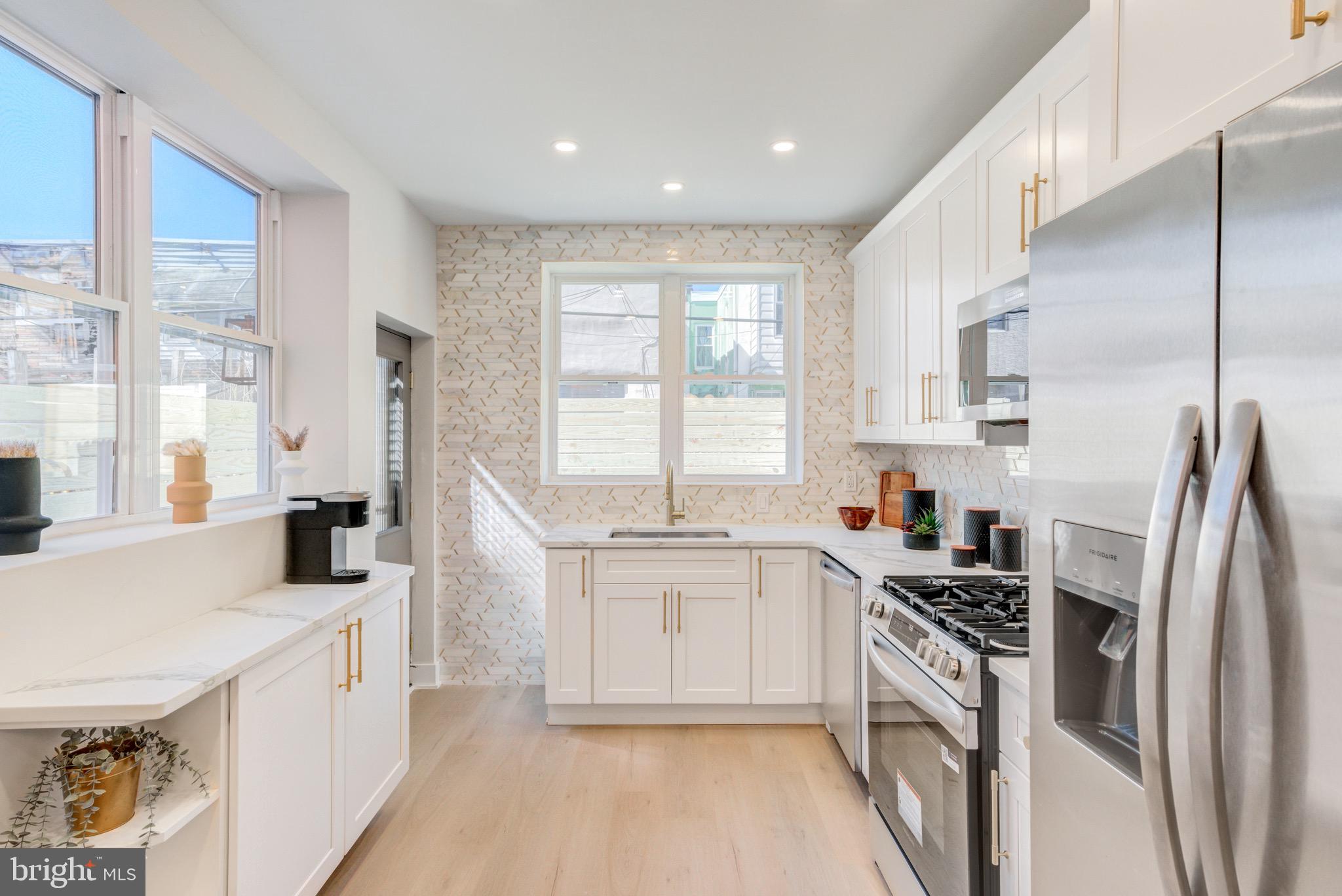 1924 South Lambert Street Philadelphia, PA 19145 - Photo 15 of 35 a kitchen with stainless steel appliances a white cabinets and a large window