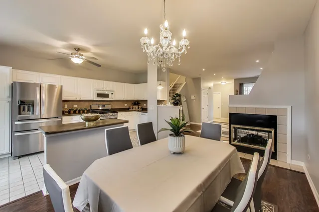 a kitchen with refrigerator a stove and chairs