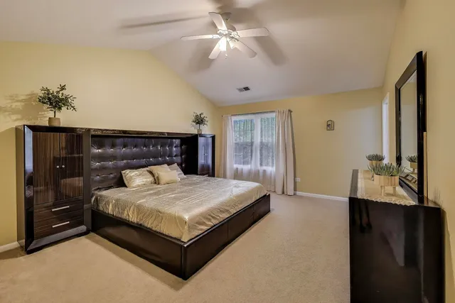 a bedroom with a large bed and a chandelier