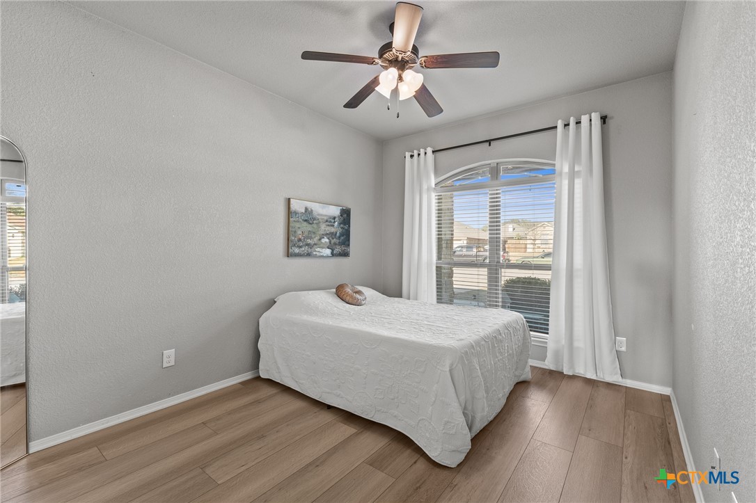 3437 Samuel Street Copperas Cove, TX 76522 - Photo 15 of 31 a bedroom with a large bed chandelier and a window