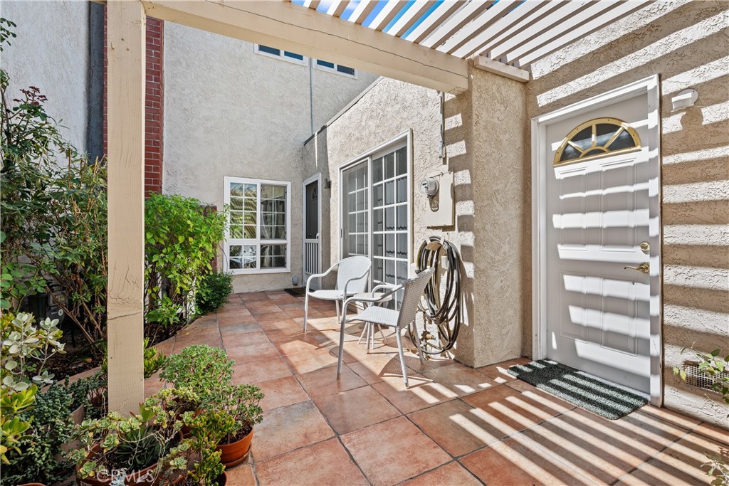 a view of a patio with table and chairs and potted plants