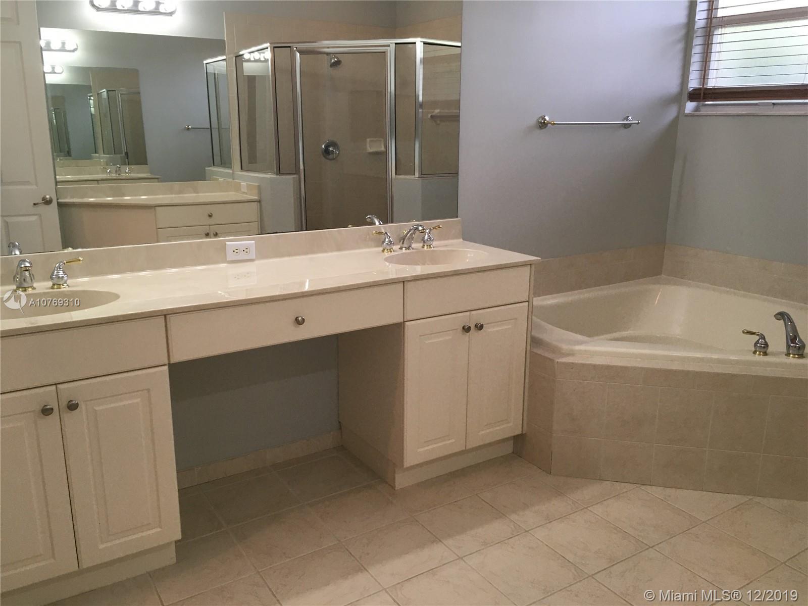 332 Southwest Otter Run Place, Unit 332 Stuart, FL 34997 - Photo 17 of 24 Master Bath with a corner garden tub to relax in as well as double sinks, a separate shower, and another counter space to use.