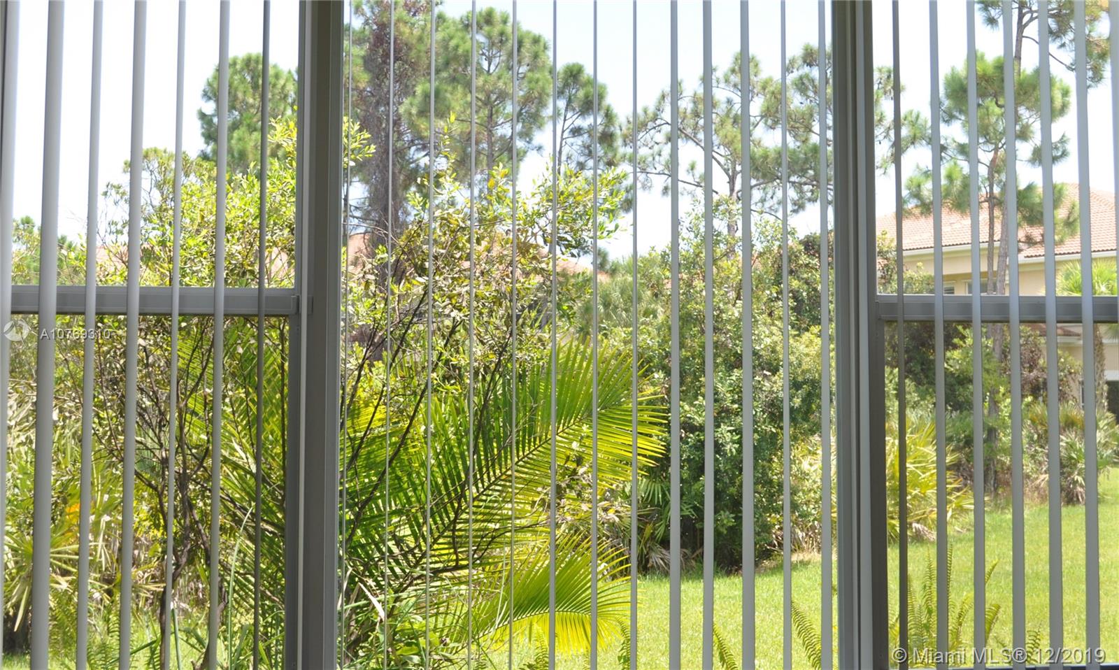 332 Southwest Otter Run Place, Unit 332 Stuart, FL 34997 - Photo 21 of 24 Florida Palms and landscaping in the backyard.