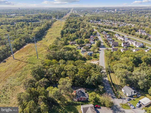 an aerial view of residential houses with outdoor space and trees