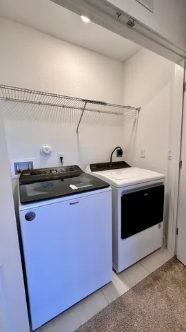 a utility room with stainless steel appliances wooden cabinets and stove