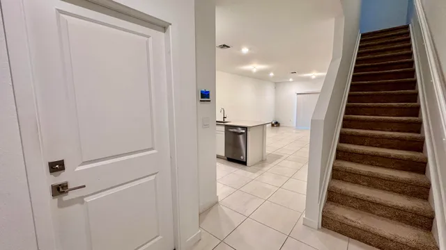 a view of a hallway with wooden cabinets and staircase