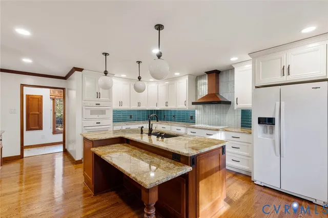 a kitchen with stainless steel appliances granite countertop a sink and a refrigerator