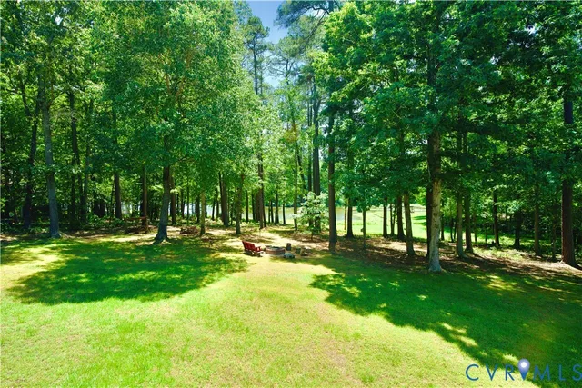 a view of a patio with table and chairs and couches with wooden fence and trees