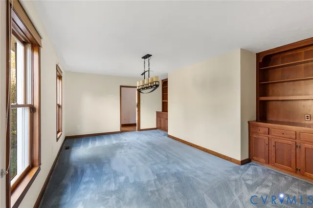 a view of empty room with window and wooden floor