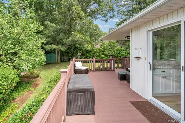 a view of a patio with table and chairs potted plants with wooden floor and fence